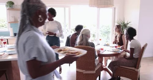 Women gather around table for lunch in home