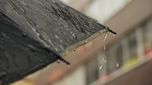 Business Man Tourist Person with Umbrella and Raincoat on Rainy European City Street Lights