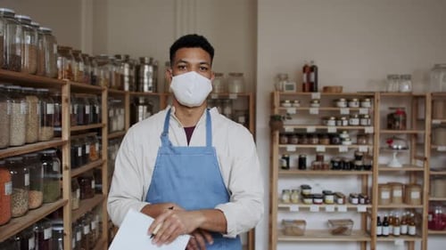 Male Owner of Zero Waste Shop Doing Audit, Looking at Camera. Coronavirus