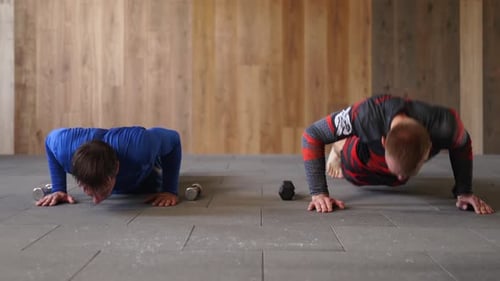 Athletic Men in Sportswear with Daidojuku Kudo Hieroglyph at Gym Do Series of Pushups and Kicks Fit