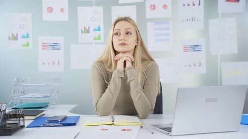 Young Woman Thinking at Her Office Desk
