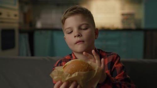 Enthusiastic Boy Enjoys Delicious Burger