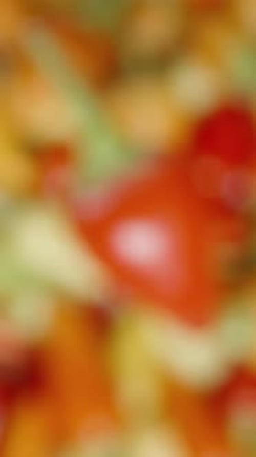 Vertical video. Top view of mini chili peppers, the camera slowly focusing on the background.