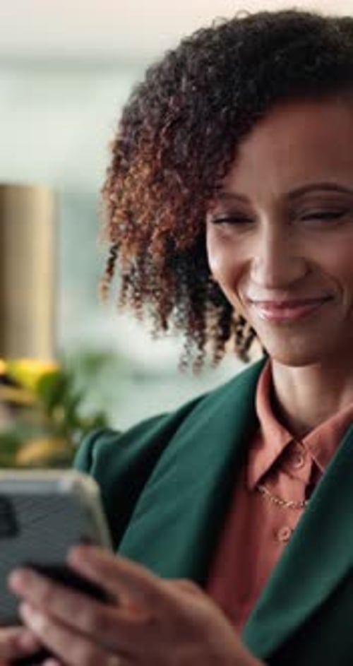 Woman smiles at her phone in relaxed setting