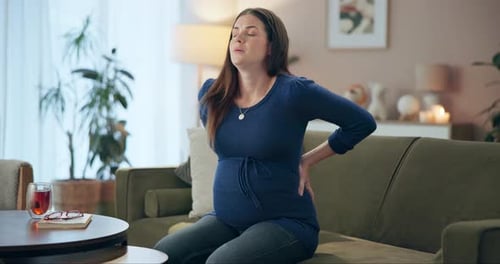 House, back pain and pregnant woman on sofa, ache and inflammation in living room