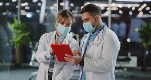 Doctors Reviewing Medical Information on Tablet in Hospital