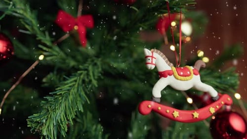 White Horse Decoration Hanging on a Christmas Tree with Snow Falling