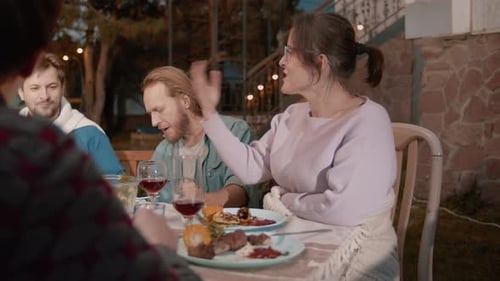 Friends Enjoy Evening Meal Together Outdoors