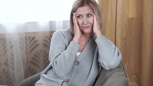 Worried Woman Holding Head in Hands Indoors