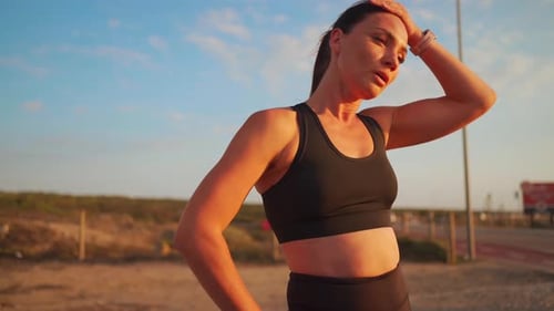 Fit Woman Resting After Workout on Sandy Beach