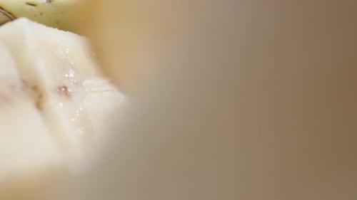 I slice banana slices while the camera rides across the table through. Dolly slider extreme close-up