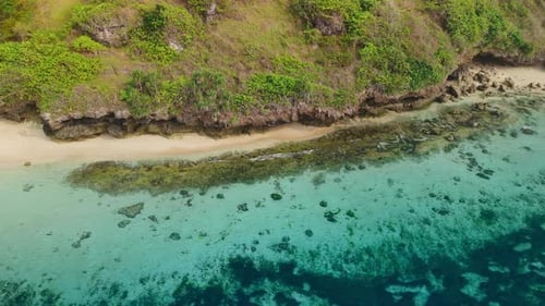 Playa tropical y costa rocosa con vista al océano turquesa desde arriba en Bali