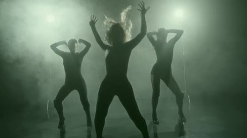 Silhouetted Women Dancing in Fog and Stage Lighting
