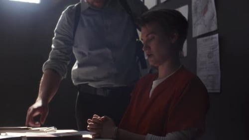 Police Detective Questioning Young Suspect in Dark Room