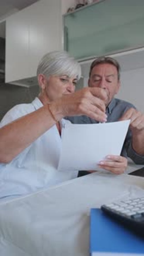 Couple Reviewing Document Together at Home