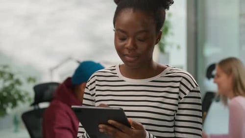 Woman Using Tablet Smiling in Modern Office