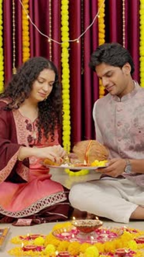 Woman and Man Perform Religious Ritual with Lamps