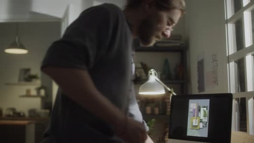 Man Drawing Designs at Desk at Home