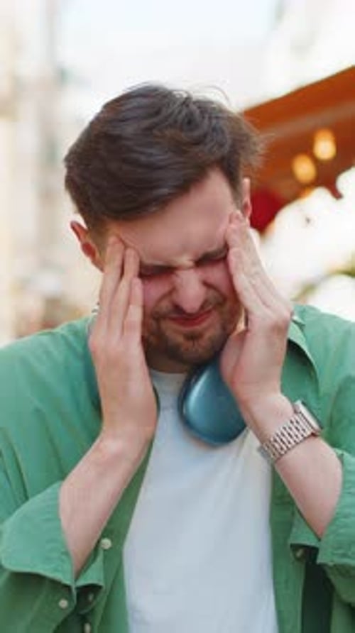 Un homme épuisé et mécontent se frotte les tempes pour soigner un mal de tête, une migraine de tension