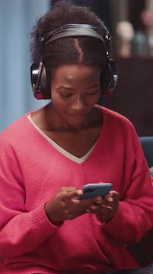 Young Woman Using Phone While Wearing Headphones
