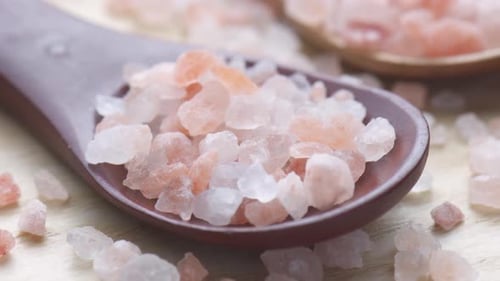 Closeup view of wooden spoons with Himalayan salt crystals