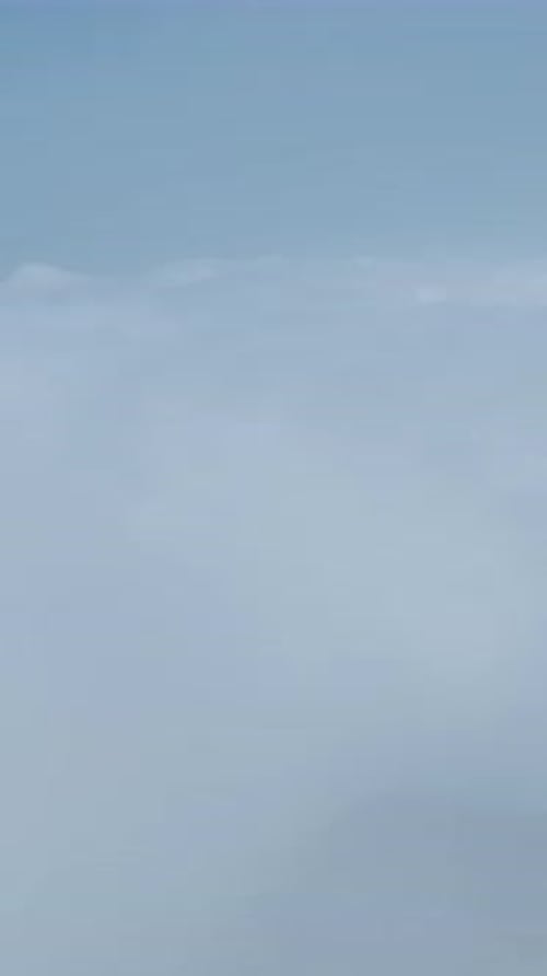 Vertikales Video Friedliche, bewölkte Berglandschaft mit blauem Himmel und grünen Wäldern für eine malerische Aussicht