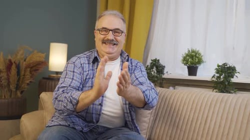 Hombre aplaude con entusiasmo ante la cámara.