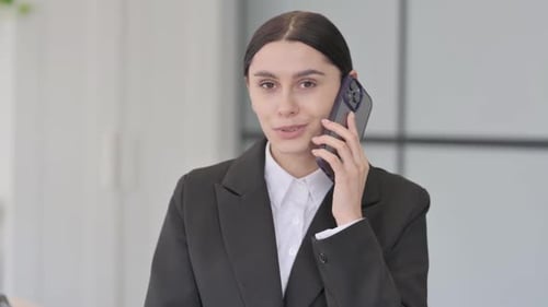 Professional Woman Talking on Smartphone in Modern Office