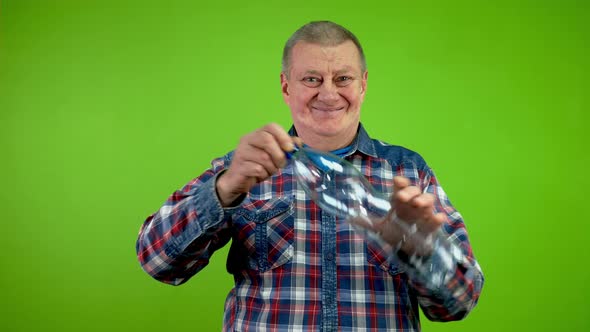 Senior Man Folding Plastic Bottle and Compressing It for Recycling ...