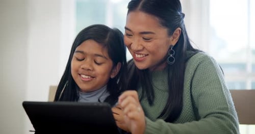 Woman and Child Looking at Tablet Together