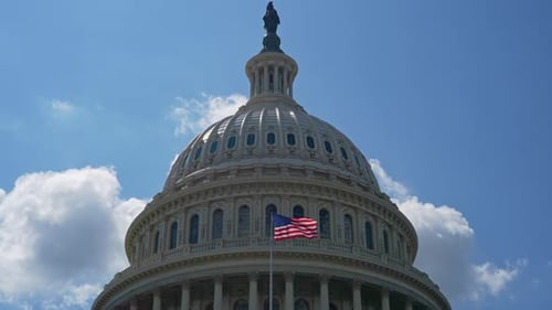 United States Capitol Building with American Flag on Sunny Day