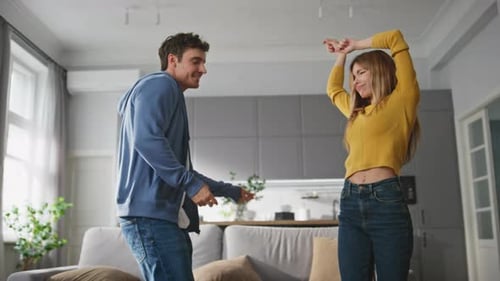 Happy Young Couple Dancing in Modern Living Room