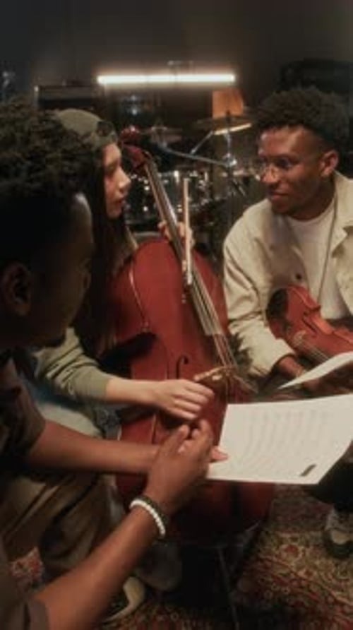 String Band Discussing Sheet Music Vertical