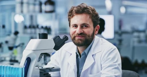 Smiling Scientist Works with Microscope in a Lab