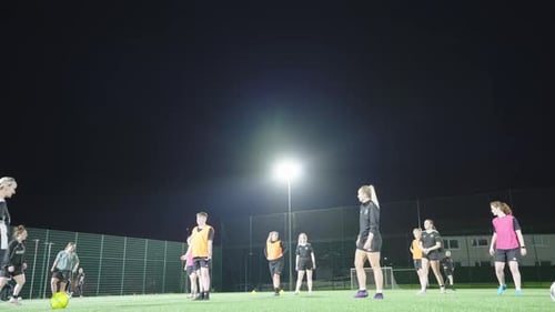 Young Adults Practicing Soccer Drills at Night