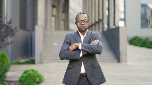Confident Businessman Standing Outside Modern Office Building