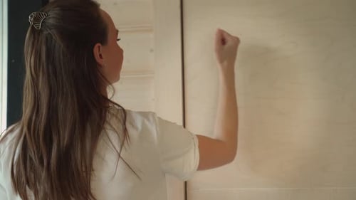 Woman Knocks on a Wooden Door Standing in the Doorway Rear View of a Woman Knocking on the Door A