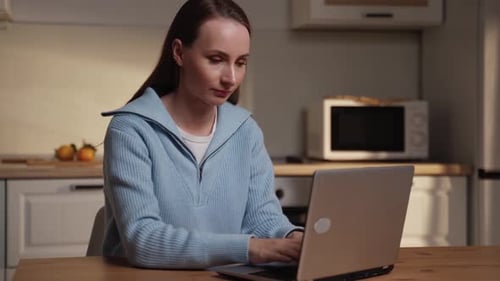 Woman Typing on Laptop in Neutral Kitchen