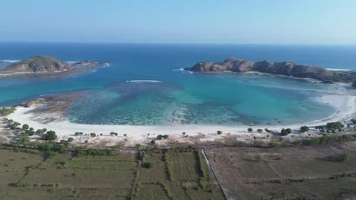 Scenic drone footage of Tanjung Aan Beach in Lombok with clear blue ocean, pristine white sand, and