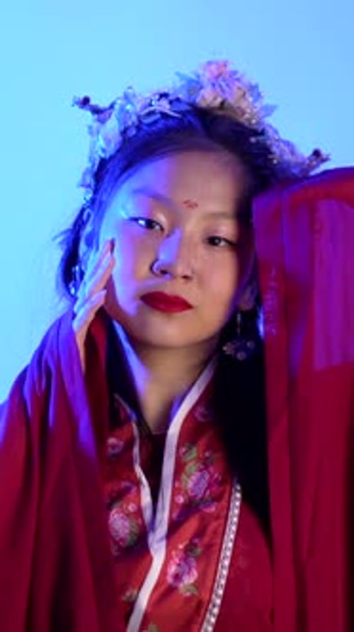 Woman Posing in Traditional Dress with Colorful Lighting