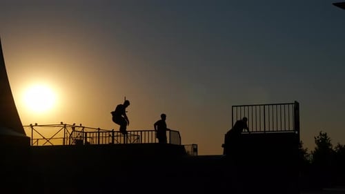 Silhouettes Jumping and Playing at Golden Sunset