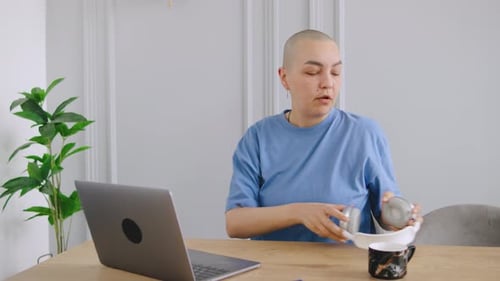 A Bald Woman Tired After Working From Home Removes Her Glasses and Headphones Closes Her Laptop to
