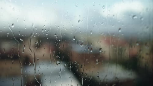 Rain Crashing on the Window of an House in the City During the Storm