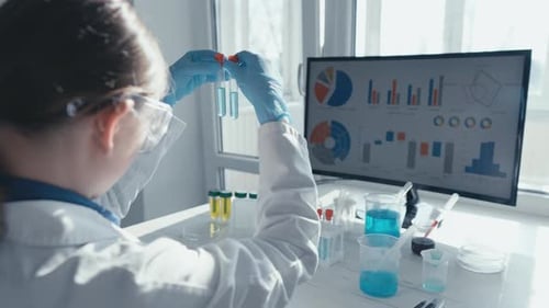 Scientist Analyzes Test Tubes in Bright Lab