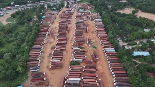 Aerial view of constant flow of freight vehicles on the main road, coupled with the adjacent lorry