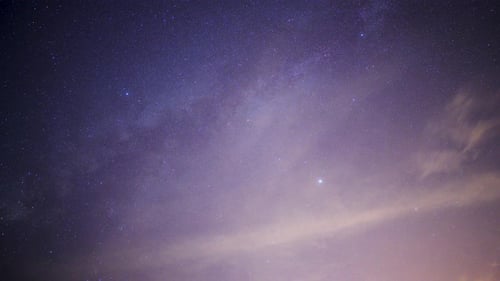 The Milky Way is clearly visible once the fast-moving white clouds disappear.