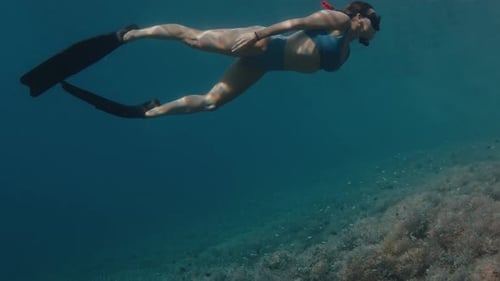Woman swims underwater in the tropical sea