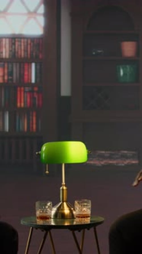 People Toasting with Whiskey in Library Setting