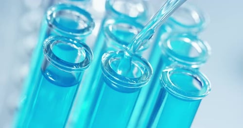In einem Labor analysiert ein Wissenschaftler mit einer Pipette eine farbige Flüssigkeit, um DNA und Molekül zu extrahieren