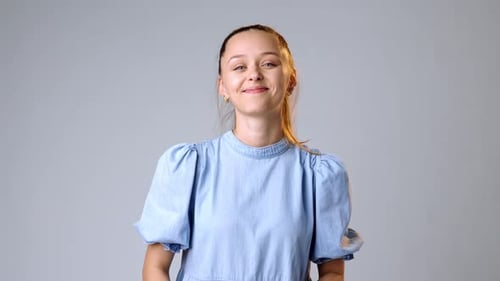 Smiling Woman in Blue Dress Nods Approvingly